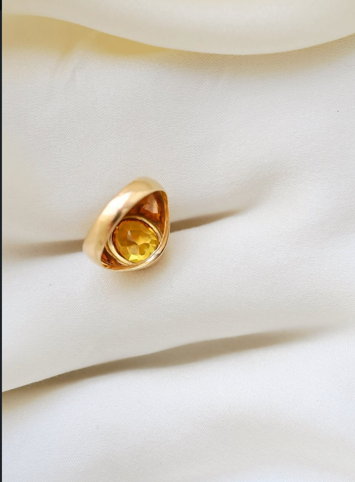 The underside showing the open back, the citrine glowing through