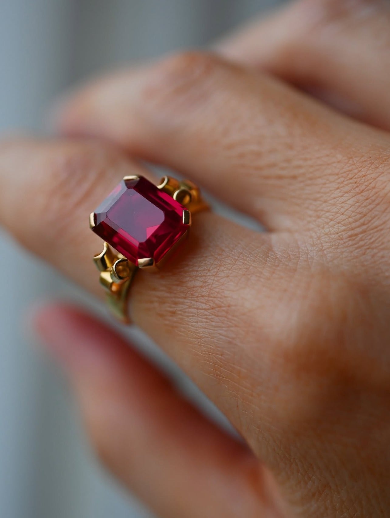 The emerald cut ruby worn on the hand, glowing deep cherry red