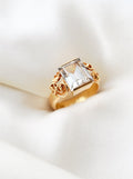 Romantic antique ring from 1896 with icy step cut rock crystal and golden flowers, on ivory silk