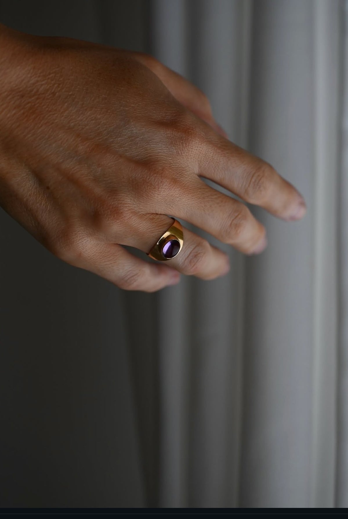 The amethyst cabochon ring worn on the hand