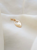 Tiny 18K gold heart padlock pendant made in Italy, resting on ivory silk