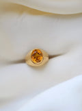 Vintage citrine pinky ring in 18K gold with ribbed dome, resting on ivory silk