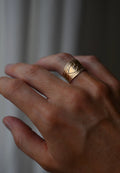 The heart cigar band worn on the hand, the stamped borders catching the light