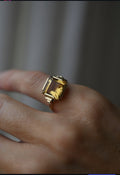 Art Deco citrine ring from 1936 in 14K gold worn on the hand, the step cut stone glowing honey gold