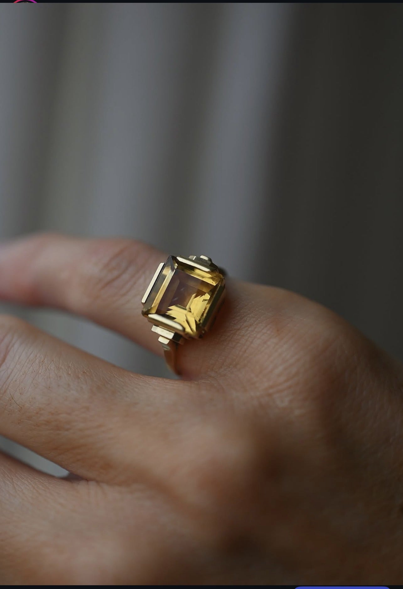 Art Deco citrine ring from 1936 in 14K gold worn on the hand, the step cut stone glowing honey gold
