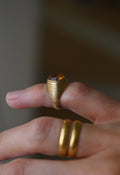 The ring on the little finger, the ribbing catching the light