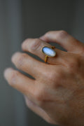 Close view of the oval moonstone, the blue glow drifting under the surface