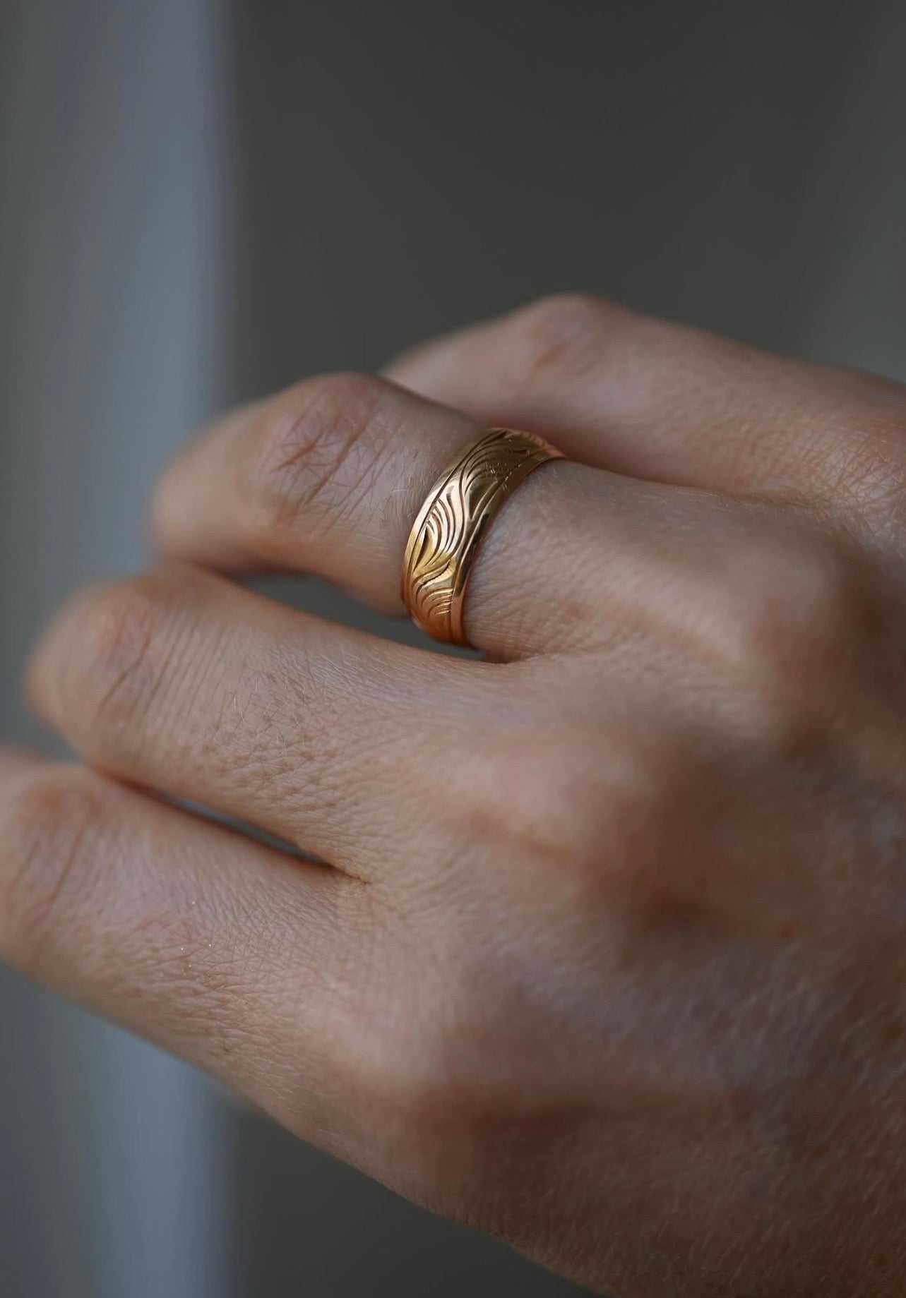 The wave engraved gold band worn on the hand, fits like a size 7 US